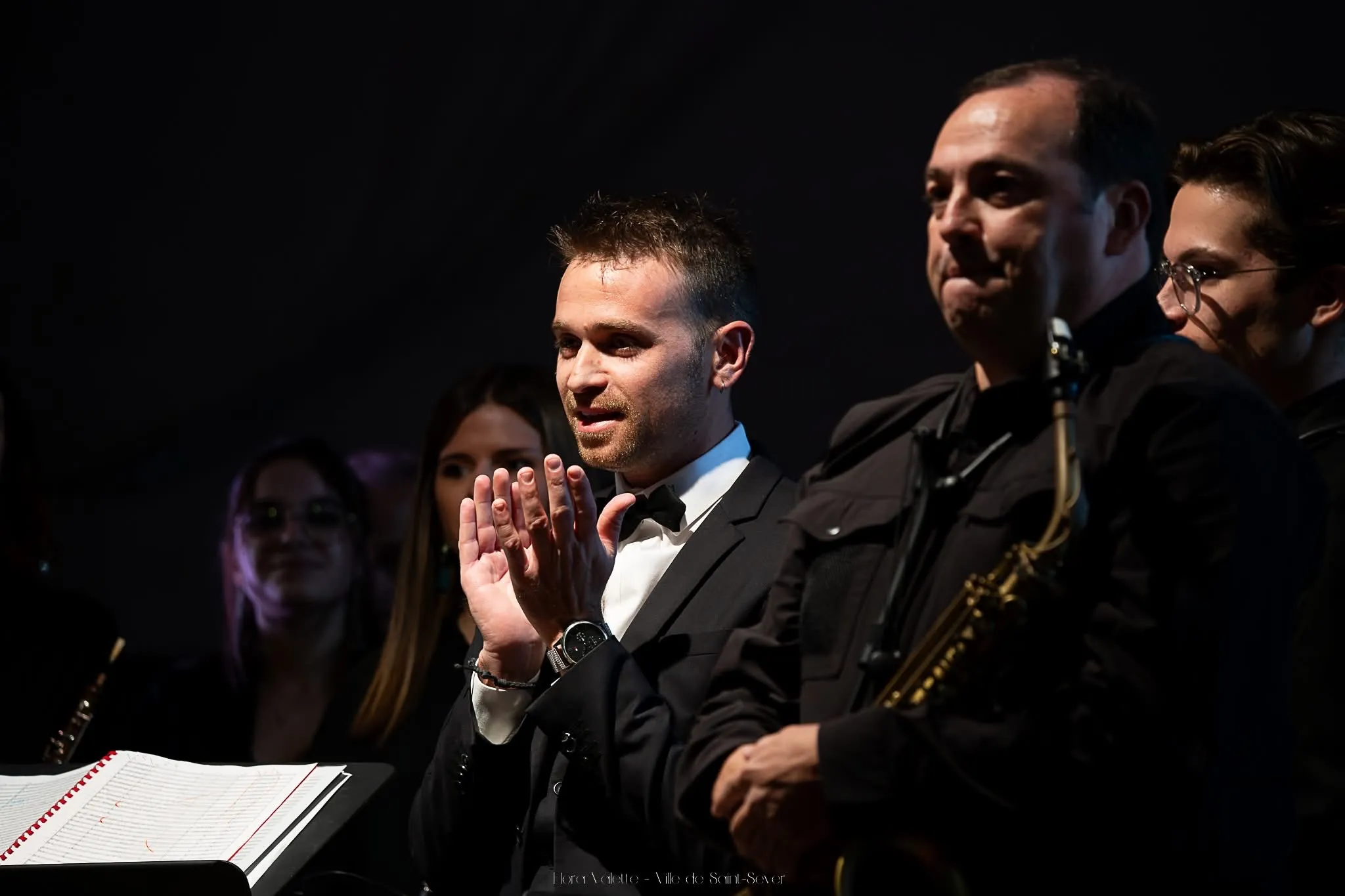 Julien Garcia en nœud papillon applaudissant ses musiciens à la fin du concert